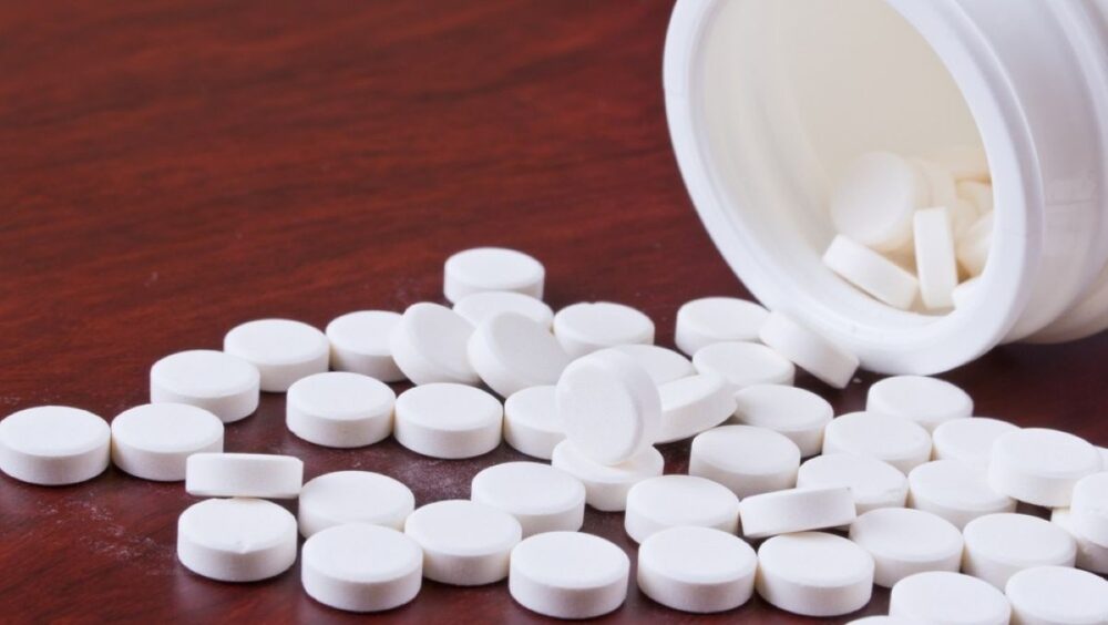 Metformin pills spilling out of a bottle onto a table